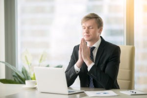 Business man praying at work