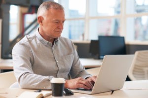 older man working on computer